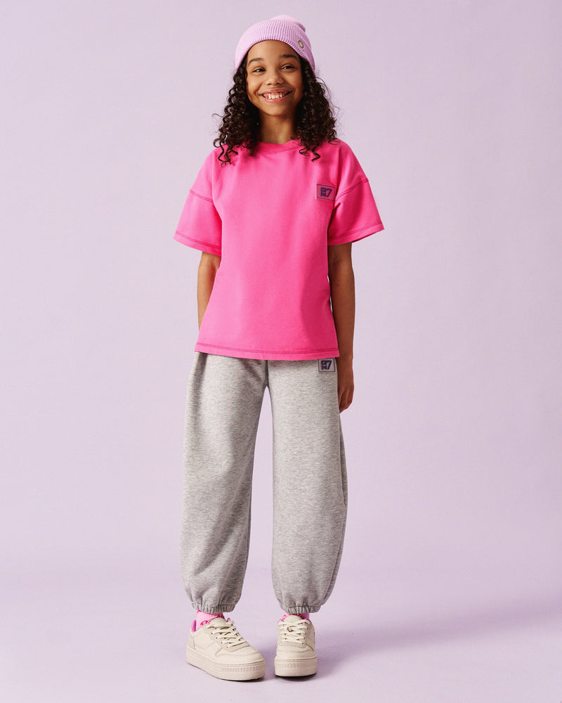 Girl in the ON7 Everyday Tee in fuchsia with melange joggers and a pink beanie