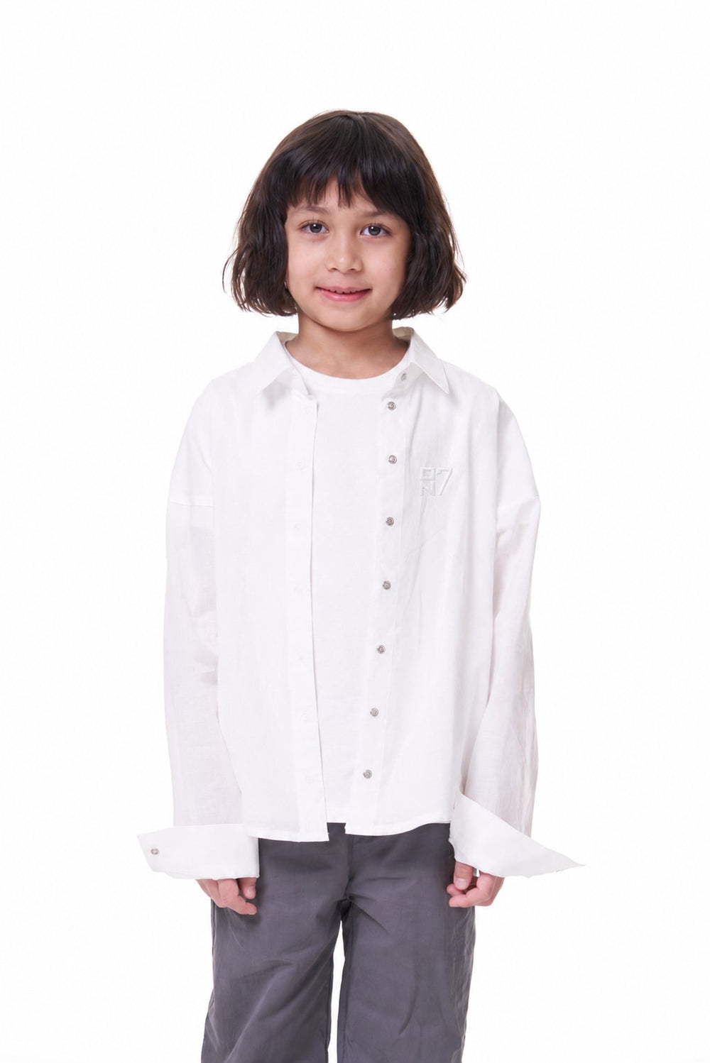 Girl wearing the ON7 Shirt in off white, open over a white tee, front view