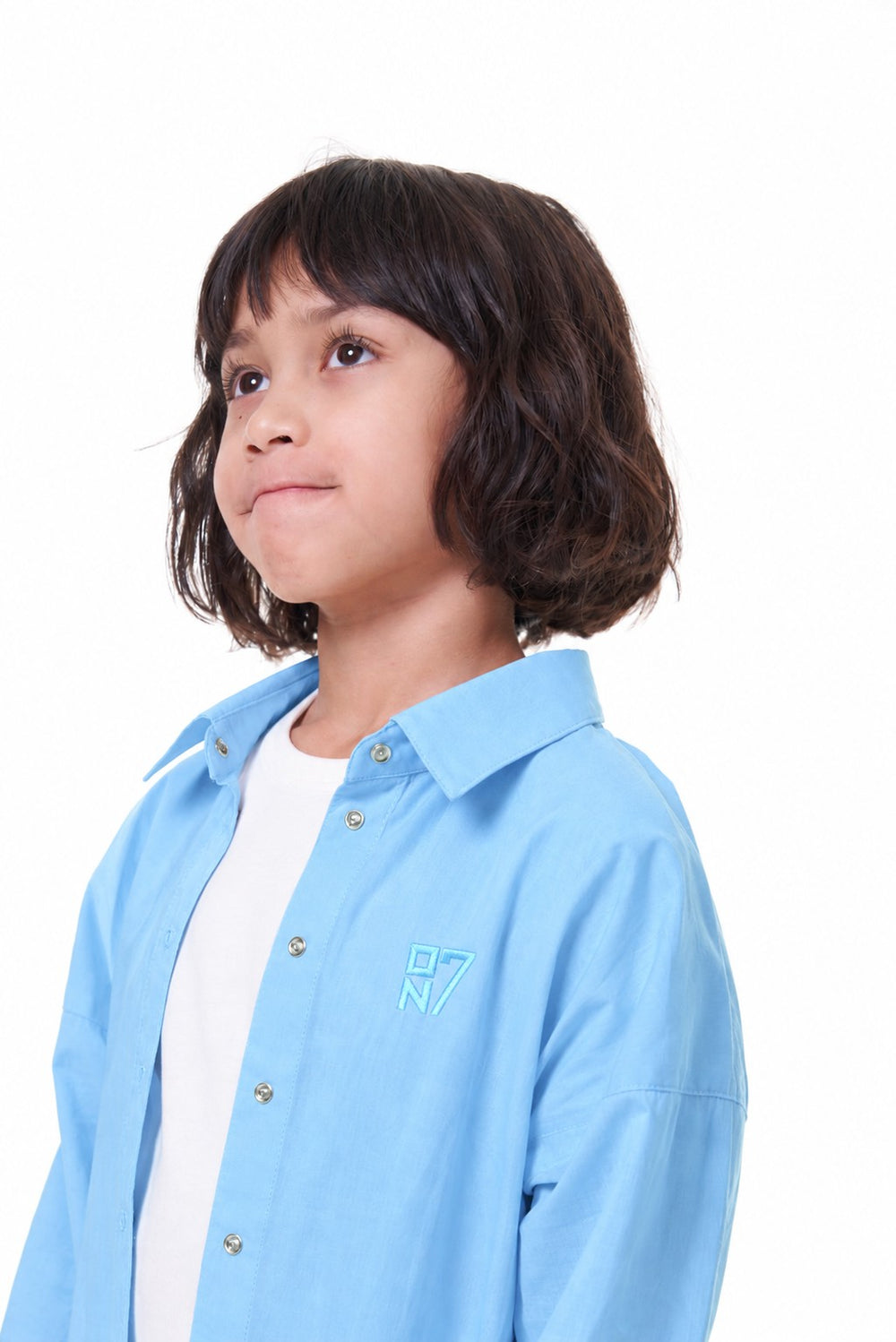 Close-up of the ON7 Shirt in sky blue with the embroidered ON7 logo