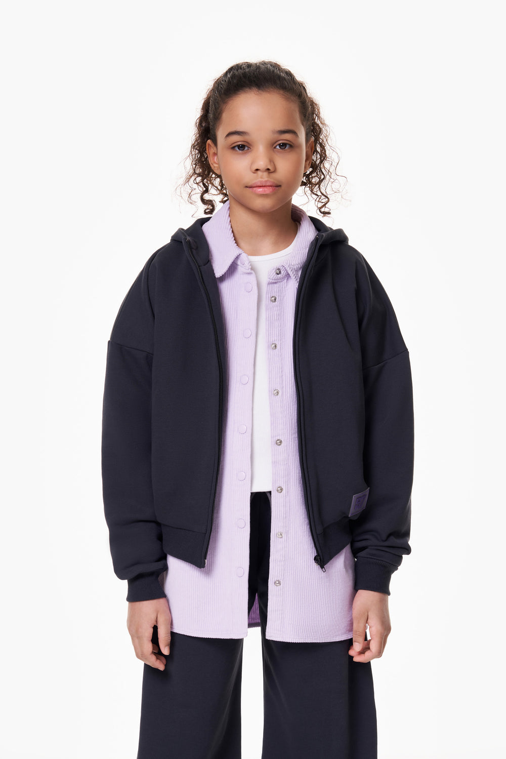 Girl wearing the ON7 Zip Hoodie in graphite, front view