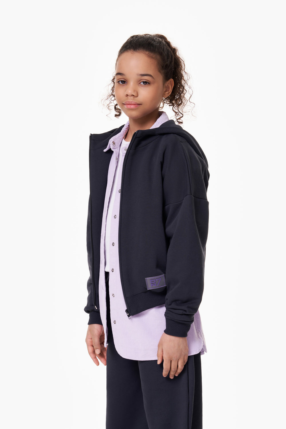 Girl wearing the ON7 Zip Hoodie in graphite, view 2 of 5